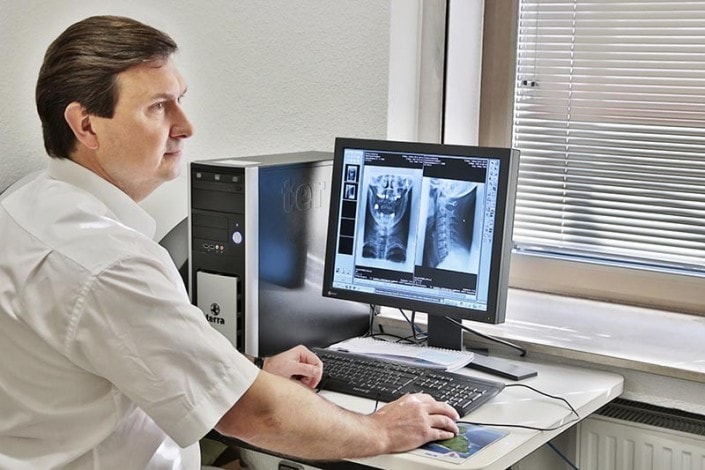 Arzt erstellt Diagnose am digitalen Röntgengerät in seiner Düsseldorfer Praxis
